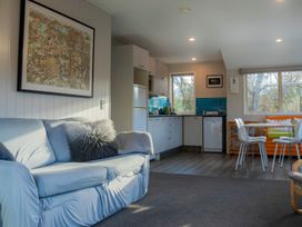 A living room with a sofa and kitchen at Arrowtown Gold - Elevated Luxury Apartment in Arrowtown