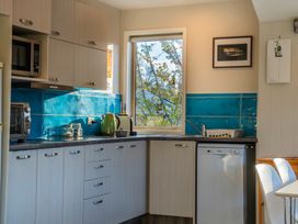 A kitchen with a microwave, kettle, sink, and dishwasher at Arrowtown Gold - Elevated Luxury Apartment in Arrowtown