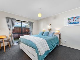 A bedroom with a bed and bedside table at Papamoa Waves - Seaside Getaway in Papamoa