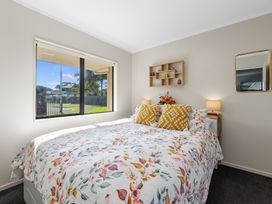 A bedroom with a bed and window at Papamoa Waves - Seaside Getaway, Papamoa