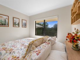 A bedroom with a bed and wall art at Papamoa Waves - Seaside Getaway in Papamoa