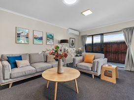 A living room with a sofa and coffee table at Papamoa Waves - Seaside Getaway in Papamoa