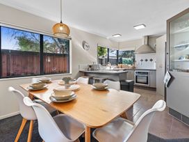 A kitchen with a dining table and chairs at Papamoa Waves - Seaside Getaway in Papamoa