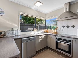 A kitchen with appliances and a window at Papamoa Waves - Seaside Getaway, Papamoa