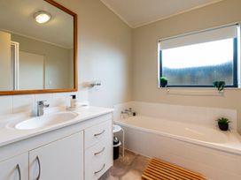A bathroom with a sink and bathtub at Papamoa Waves - Seaside Getaway in Papamoa