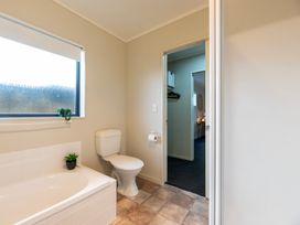 A bathroom with a bathtub and a toilet at Papamoa Waves - Seaside Getaway, Papamoa