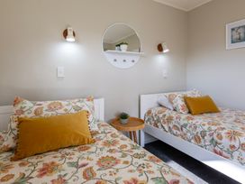 A bedroom with two beds and a bedside table at Papamoa Waves - Seaside Getaway in Papamoa