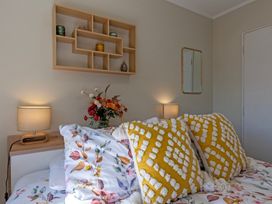 A bedroom with a bed and decorative items at Papamoa Waves - Seaside Getaway, Papamoa