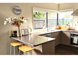 A kitchen with a countertop, sink, and flower vase at Papamoa Waves - Seaside Getaway, Papamoa