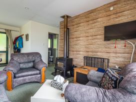 A living room with sofas and a wood stove at Alpine Charm - Ohakune Holiday Home in Ohakune