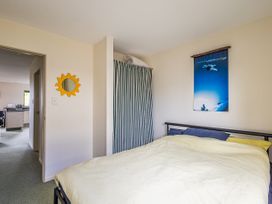 A bedroom with a bed and a mirror at Alpine Charm - Ohakune Holiday Home in Ohakune