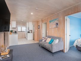 A living room with a sofa and a TV at Home Away From Home In Whangamata, Whangamata