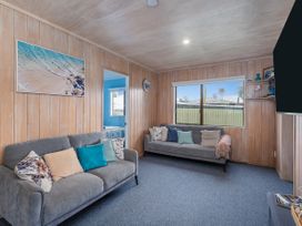 A living room with sofas and a window at Home Away From Home In Whangamata, Whangamata