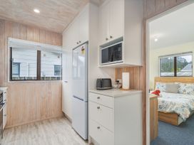 A kitchen with appliances and a window at Home Away From Home In Whangamata, Whangamata
