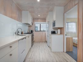 A kitchen with appliances and cabinetry at Home Away From Home In Whangamata