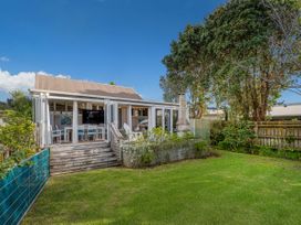 A house with a garden and deck at Home Away From Home In Whangamata