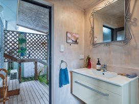 A bathroom with a sink and mirror at Home Away From Home In Whangamata
