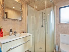 A bathroom with a shower and sink at Home Away From Home In Whangamata, Whangamata