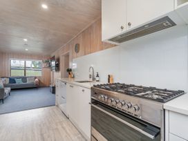 A kitchen with stove and sink at Home Away From Home In Whangamata