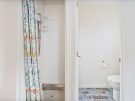 A bathroom with a shower and toilet at Home Away From Home In Whangamata