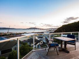 A balcony with a table and chairs overlooking the ocean at Wellington Holiday in Wellington
