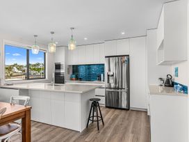 A kitchen with a refrigerator and countertop at Kawau Bay Escape - Snells Beach Holiday Home