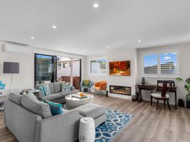 A living room with a sofa, coffee table, and a television at Kawau Bay Escape - Snells Beach