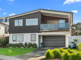 A house with a balcony and garage at Kawau Bay Escape - Snells Beach Holiday Home in Snells Beach