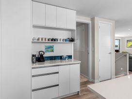 A kitchen with shelves and cabinets at Kawau Bay Escape - Snells Beach