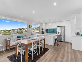 A kitchen with dining table and chairs at Kawau Bay Escape - Snells Beach Holiday Home Snells Beach