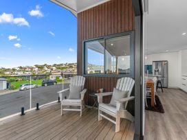 An outdoor terrace with chairs and a view at Kawau Bay Escape - Snells Beach Holiday Home