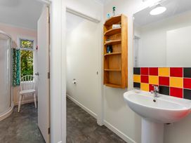 A bathroom with a shower, sink, and a toilet at Turangi Holiday Home in Turangi