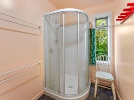 A bathroom with a shower and a chair at Turangi Holiday Home in Turangi