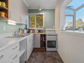 A kitchen with sink, cabinets, oven, and window at Turangi Holiday Home in Turangi