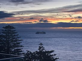 A ship on the ocean during sunset at Cape View - Napier Holiday Home, Bluff Hill