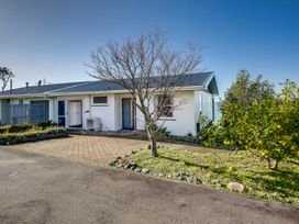 A house with a tree and garden at Cape View - Napier Holiday Home Bluff Hill