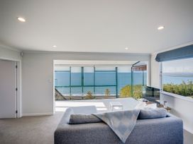 A living room with a sofa and television at Cape View - Napier Holiday Home Bluff Hill