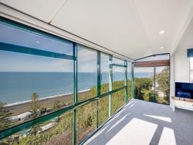A conservatory with a view of the ocean at Cape View - Napier Holiday Home Bluff Hill