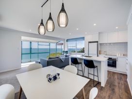 A living room with a kitchen area at Cape View - Napier Holiday Home in Bluff Hill