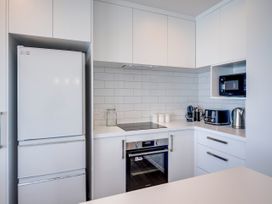 A kitchen with appliances such as a refrigerator, microwave, oven, and kettle at Cape View - Napier Holiday Home in Bluff Hill