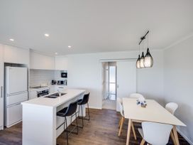 A kitchen with appliances and dining area at Cape View - Napier Holiday Home Bluff Hill