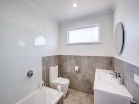 A bathroom with a bathtub and toilet at Cape View - Napier Holiday Home in Bluff Hill