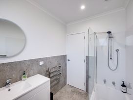 A bathroom with sink, shower, and mirror at Cape View - Napier Holiday Home in Bluff Hill