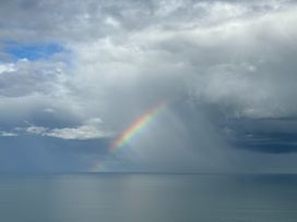 A rainbow over the sea at Cape View - Napier Holiday Home Bluff Hill