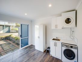 A laundry room with a washing machine and dryer at Cape View - Napier Holiday Home, Bluff Hill