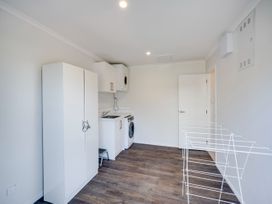 A laundry room with a washing machine and dryer at Cape View - Napier Holiday Home, Bluff Hill