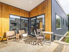 An outdoor patio with chairs and a table at Alpine Retreat - Ohakune Holiday Home in Ohakune