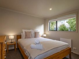 A bedroom with a bed and lamp at Alpine Retreat - Ohakune Holiday Home in Ohakune