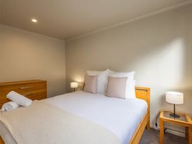 A bedroom with a bed and nightstand at Alpine Retreat - Ohakune Holiday Home
