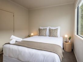 A bedroom with a bed and lamp at Alpine Retreat - Ohakune Holiday Home